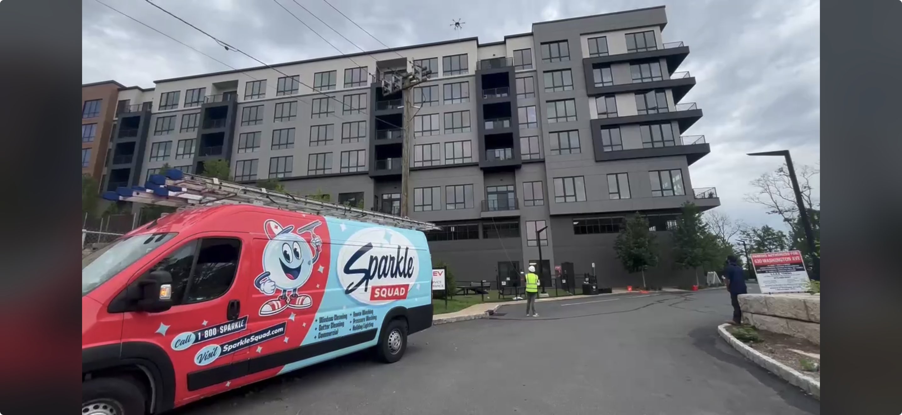 Sparkle Squad commercial service van at a multi-story property