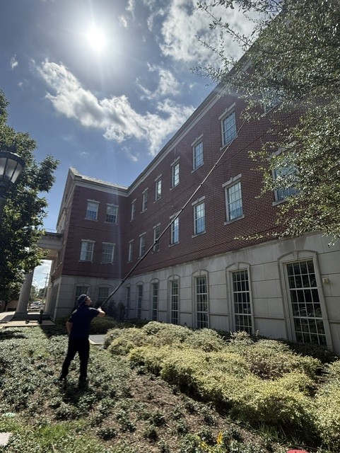Technician using a water-fed pole on upper exterior windows